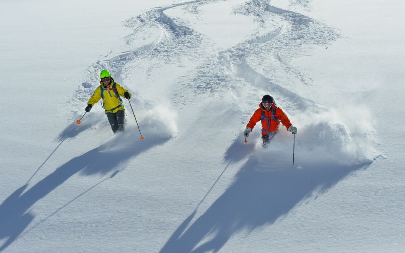 helicopter-skiing-two-skiers-side-by-side-min