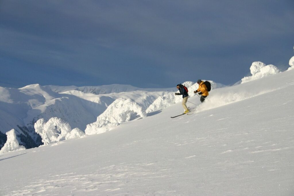 heli-skiing-bc-prices-two-skiers-min