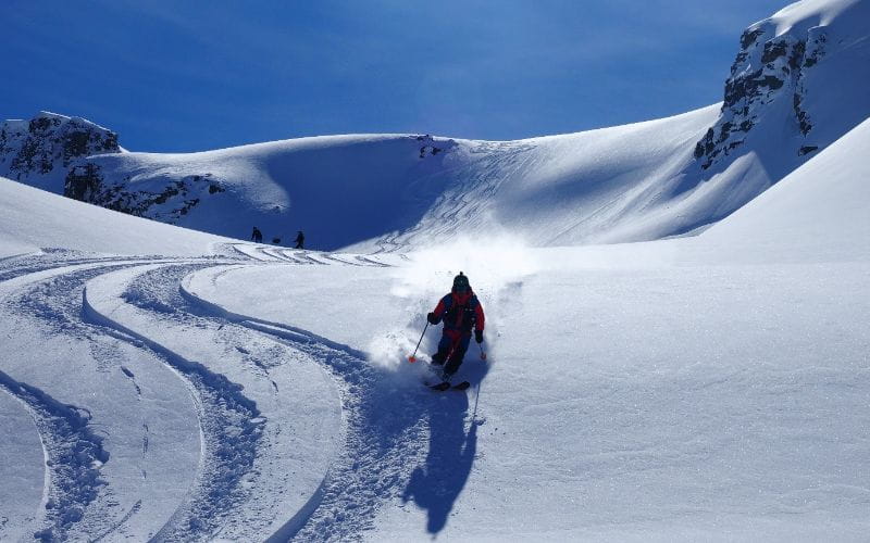 affordable-heli-skiing-skiing-down-mountain