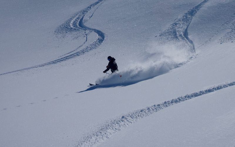 affordable-heli-skiing-skiing-down-mountain