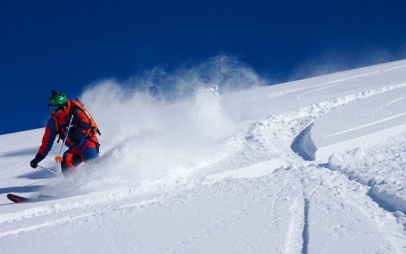 heli-skiing-bc-prices-skier-going-down-mountain