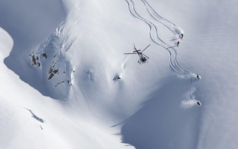 heli-skiing-bc-prices-helicopter-flying-over-mountain (1)